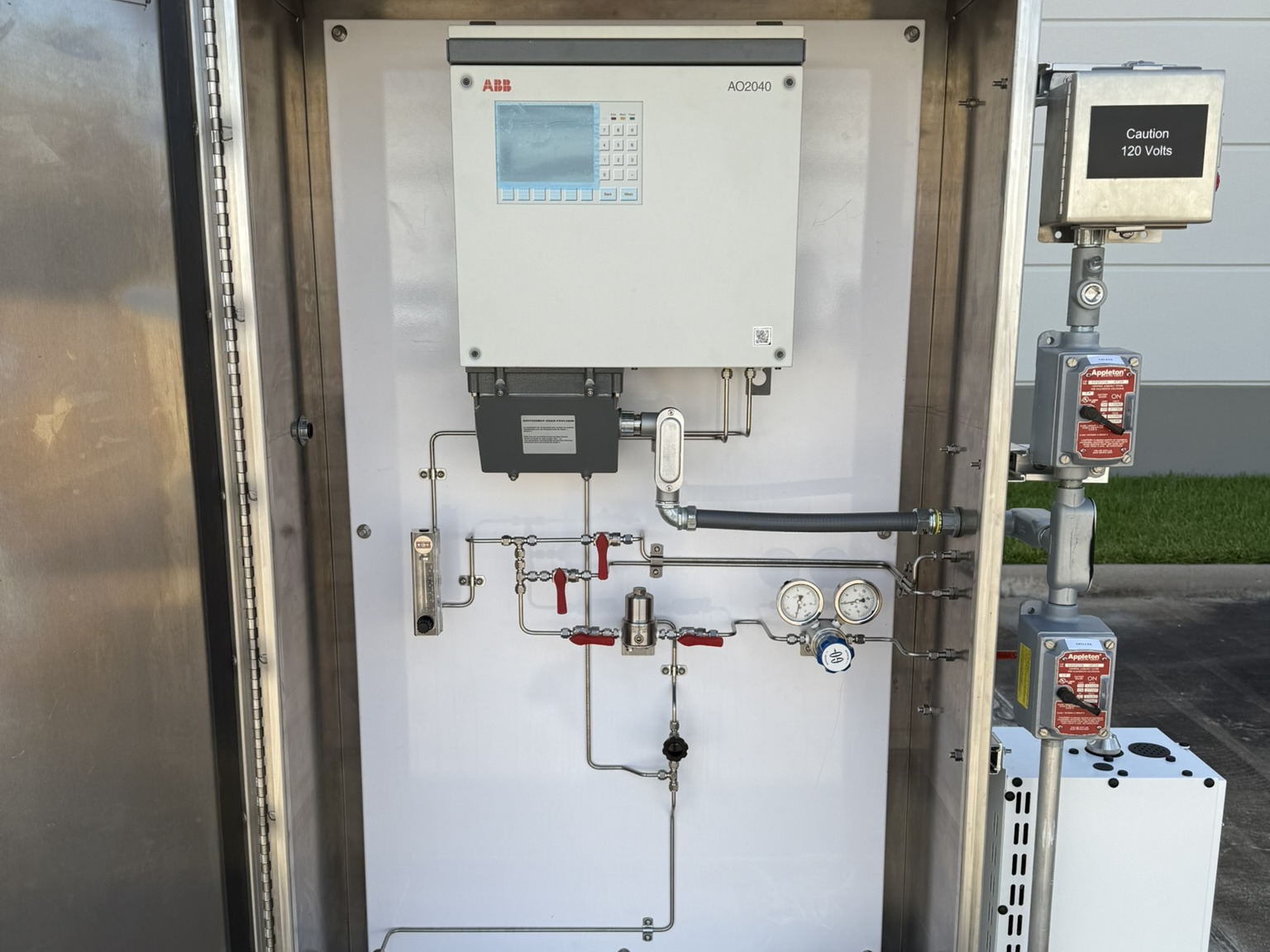 Open stainless cabinet with an integrated continuous gas analyzer and sample tubing